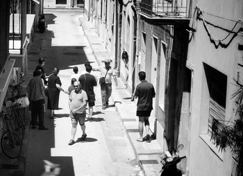 People walking on street amidst buildings in city