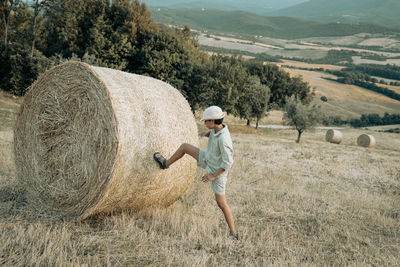 Rear view of woman sitting on hay