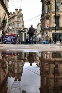 Reflection of buildings in puddle on street