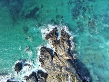 High angle view of waves splashing on rocks