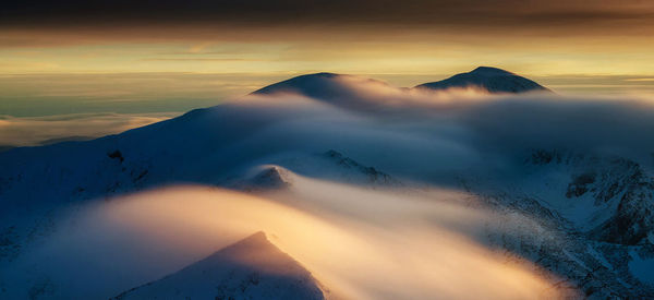 Scenic view of snowcapped mountains against sky during sunset