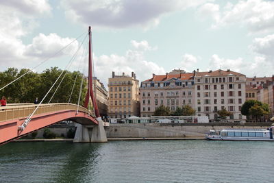 View of bridge over river in city against sky