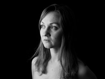 Portrait of a beautiful young woman over black background