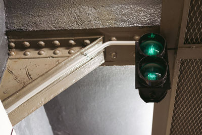 Low angle view of illuminated lighting equipment on wall