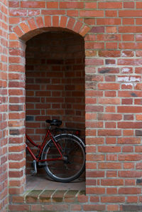 Bicycle leaning against brick wall