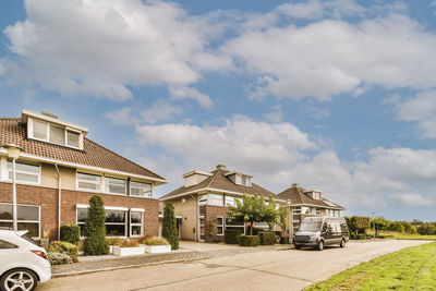 Cars on street against sky