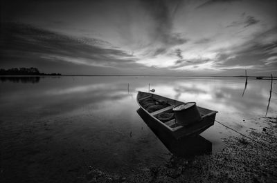 Boat moored on beach against sky