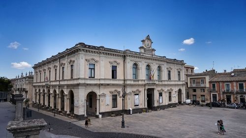 Statue of historic building against blue sky