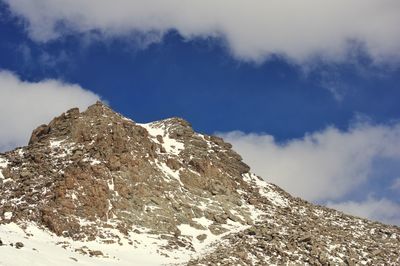 Low angle view of snowcapped mountain against sky