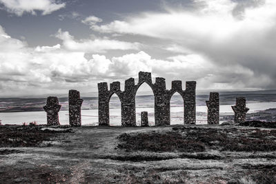 Old ruins by sea against sky