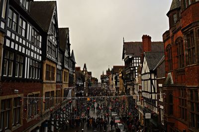 People on street amidst buildings in city