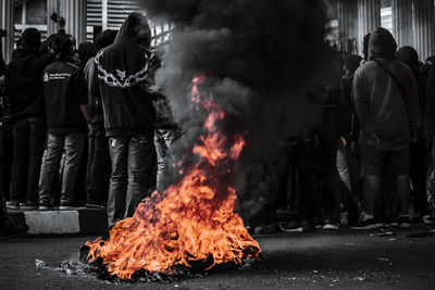 People standing by fire on street in city