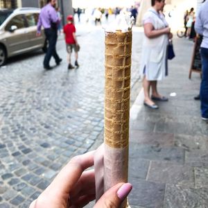 Midsection of person holding ice cream on street