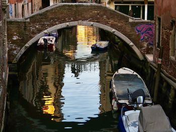 Boats in canal amidst buildings in city