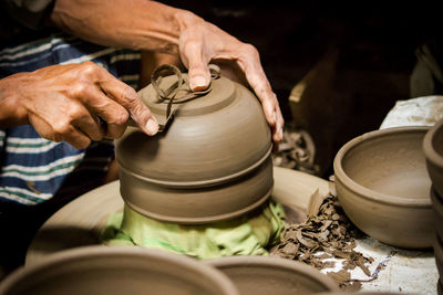 Midsection of man shaping bowl in workshop