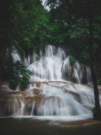 Long exposure wide angle of scenic waterfall in rainforest. no people. kanchanaburi, thailand.