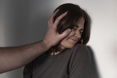 Close-up portrait of human hand against wall