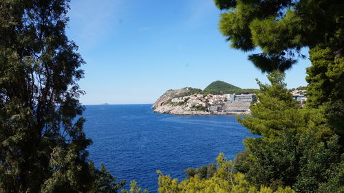 Scenic view of sea by buildings against sky