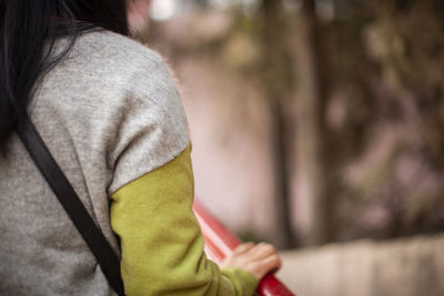 Midsection of woman standing by railing