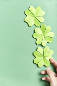 Midsection of person holding paper against green background