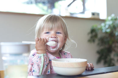 Cute girl eating ice cream at home