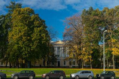Cars on street in city against sky