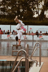 People in swimming pool against trees