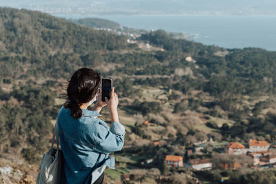 Side view of young woman standing on mountain