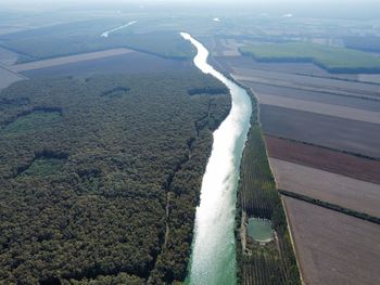 High angle view of river amidst land seen through airplane