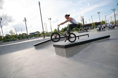 Side view of man riding bicycle against sky