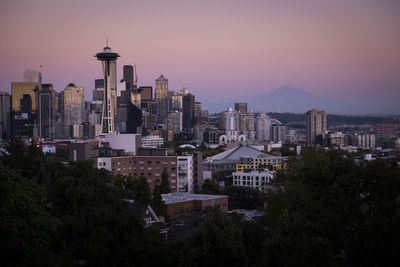 Buildings in city against sky during sunset