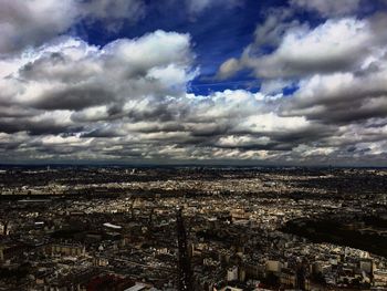 Aerial view of cityscape against cloudy sky