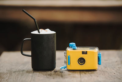 Close-up of drink by camera on wooden table