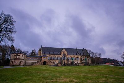 Old building on field against cloudy sky