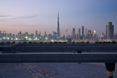 Illuminated buildings in city against sky