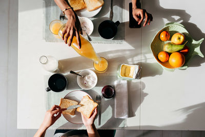 Top view of multiethnic young women eating healthy breakfast food at table in morning at home