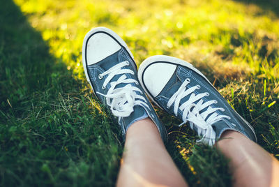 Low section of person wearing shoes on grass