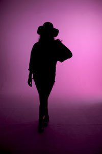 Silhouette woman standing against pink background