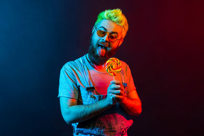 Young man wearing mask against black background