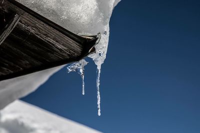 Low angle view of frozen water against sky
