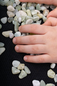 High angle view of woman hand holding pebbles