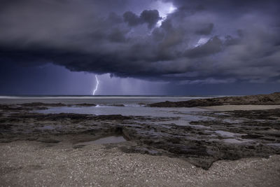 Scenic view of sea against storm clouds