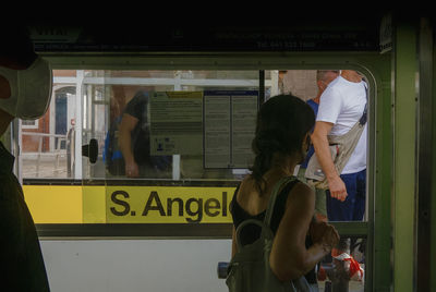 Rear view of people standing on train window