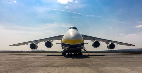 Airplane on airport runway against sky