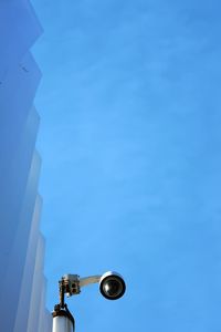 Low angle view of security camera against sky