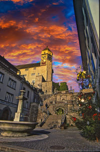 Buildings in city against sky during sunset