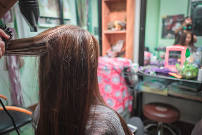 Rear view of woman sitting at barber shop