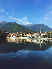 Scenic view of lake and mountains against blue sky