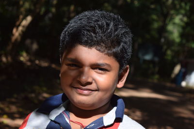 Close-up portrait of smiling boy at park