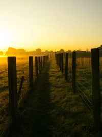 Wooden posts on field against clear sky